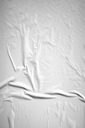 a black and white photo of a bed with white sheets