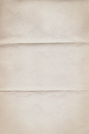 A textured, off-white paper with three horizontal creases running across. The surface appears slightly worn with subtle discoloration and minor graininess.