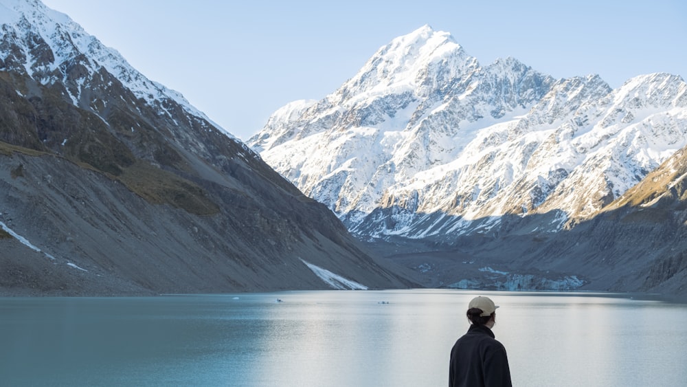 a person standing in front of a mountain lake