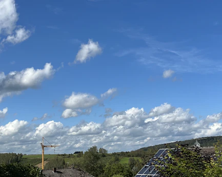 A wide aerial view of the Bulli Creek North Energy Hub site under a bright blue sky, showcasing solar panels and open land.