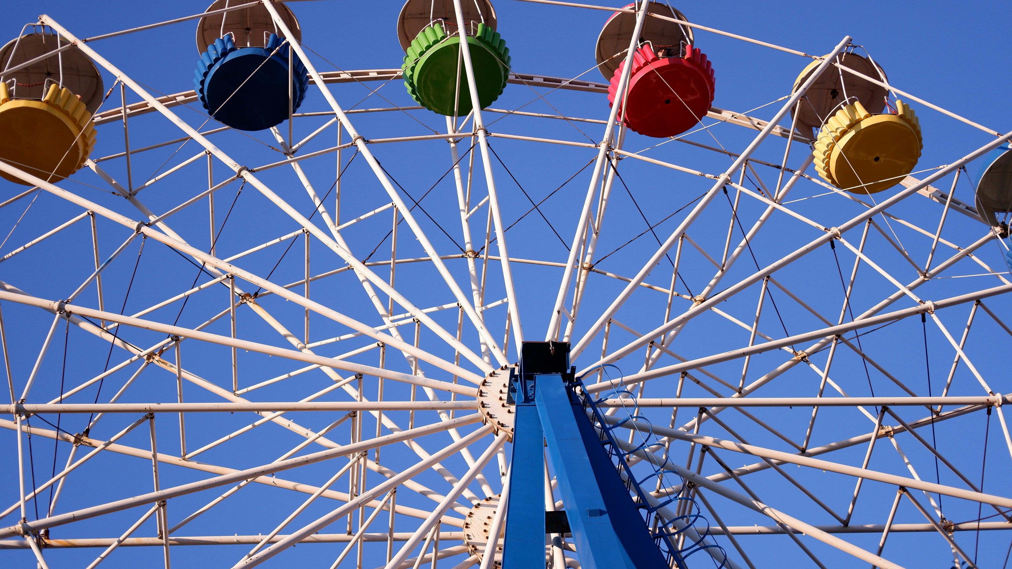 a ferris wheel with four colored wheels on a clear day