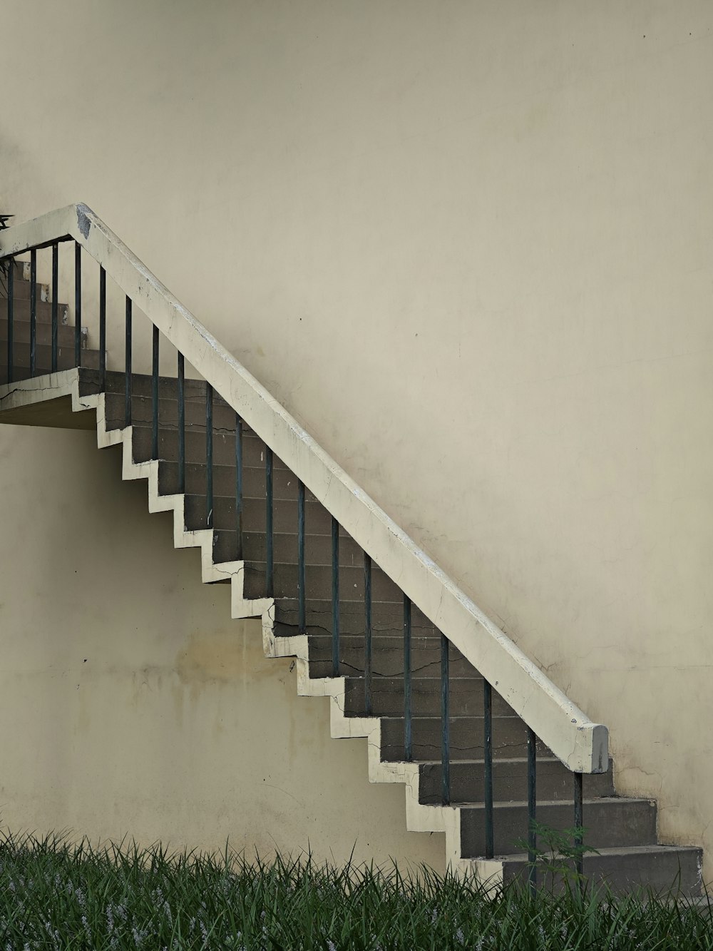 a white stair case next to a wall