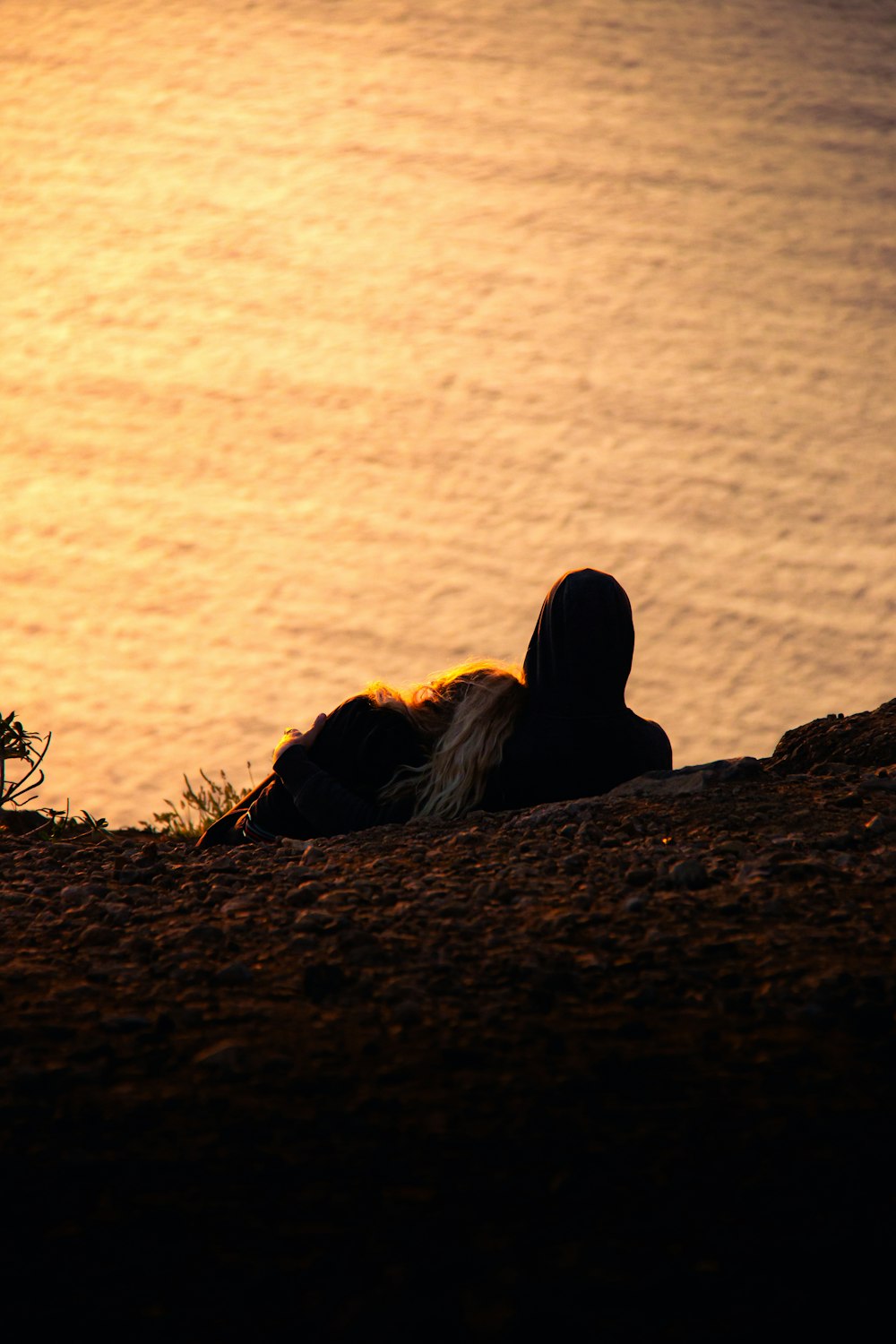 a person laying on the ground next to a body of water