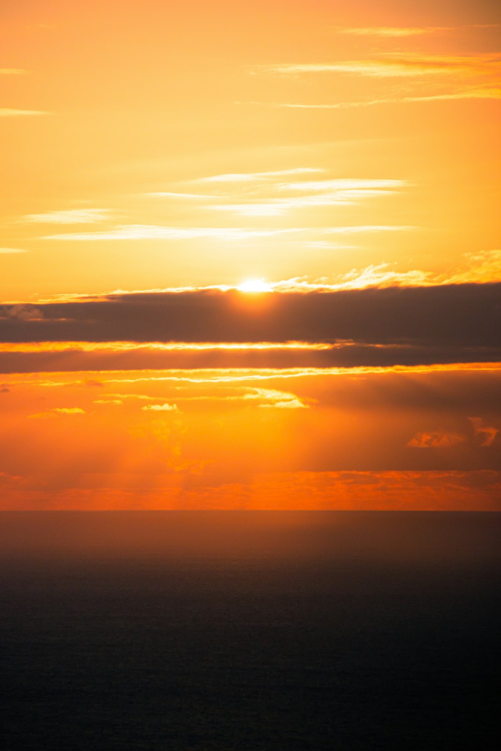 太陽は前景に飛行機で海の上に沈んでいます