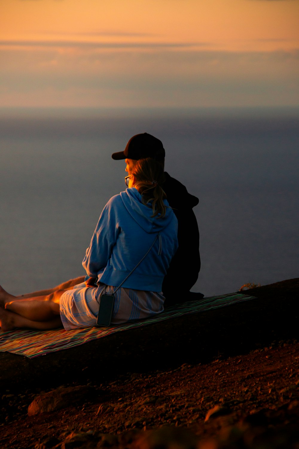 a man sitting on top of a surfboard next to the ocean