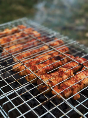 Chef carefully flipping marinated chicken skewers on the grill.
