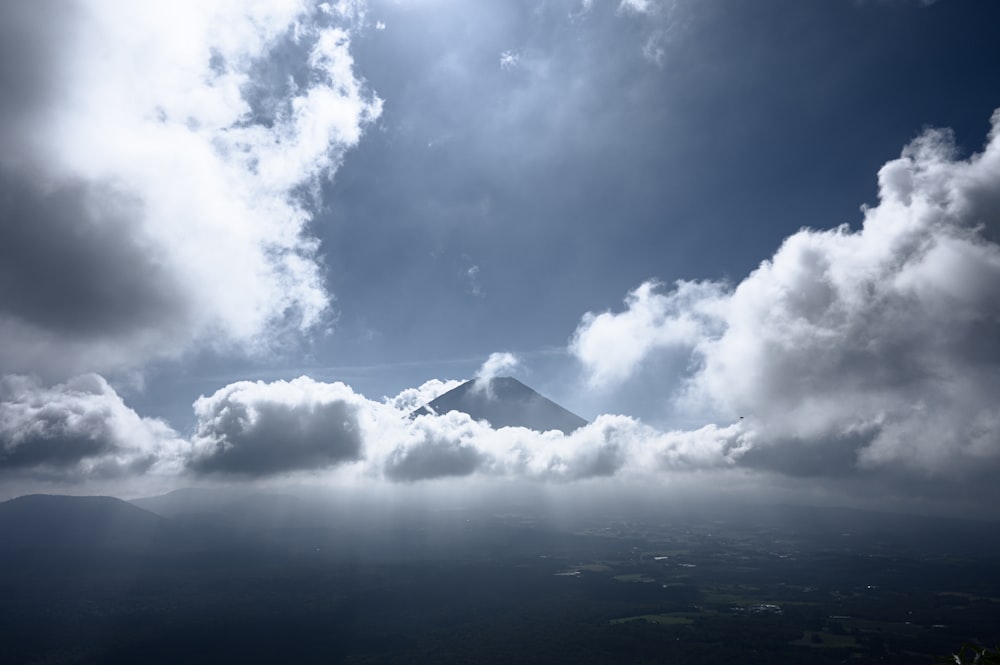 Una montaña en la distancia con nubes en primer plano