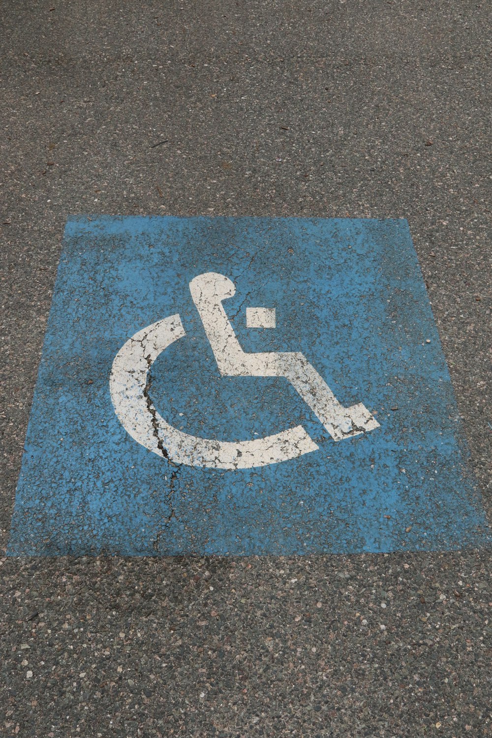 a handicap sign painted on the ground in a parking lot