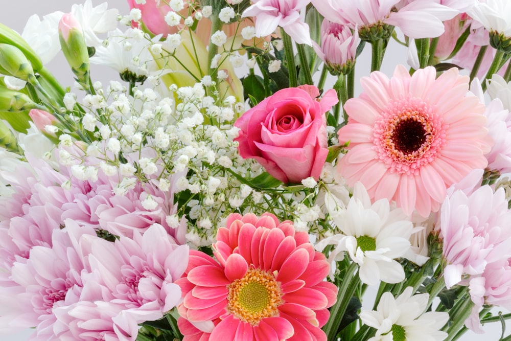 a vase filled with lots of pink and white flowers