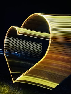 A soft gold abstract heart glowing gently against a warm beige background.