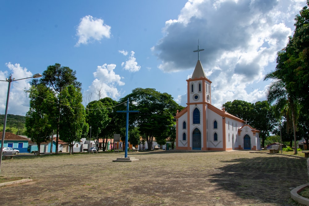 a church with a clock tower in the middle of a field