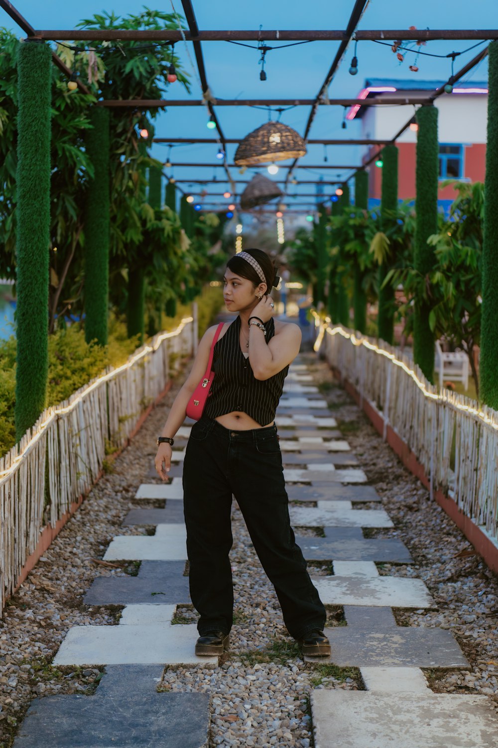 a woman standing in the middle of a walkway