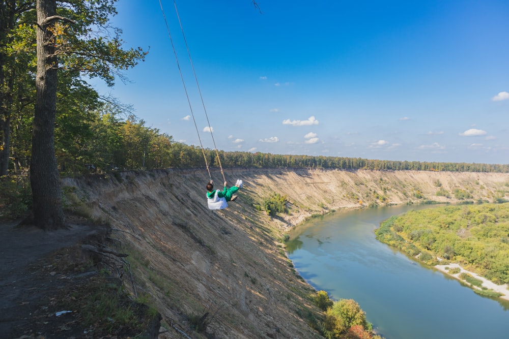 a person on a zip line above a river