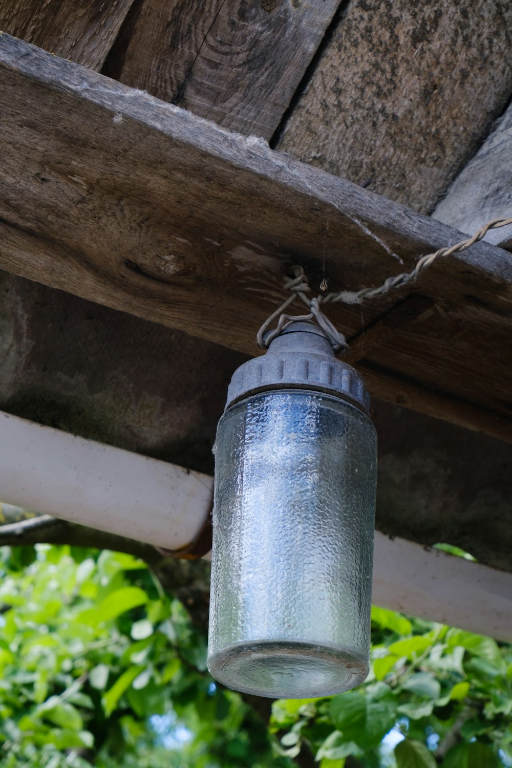 a mason jar hanging from a wooden roof