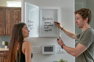 A family happily checking their shared shopping list on a phone in a cozy kitchen.