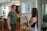 A smiling real estate agent handing keys to a happy client in a modern home.