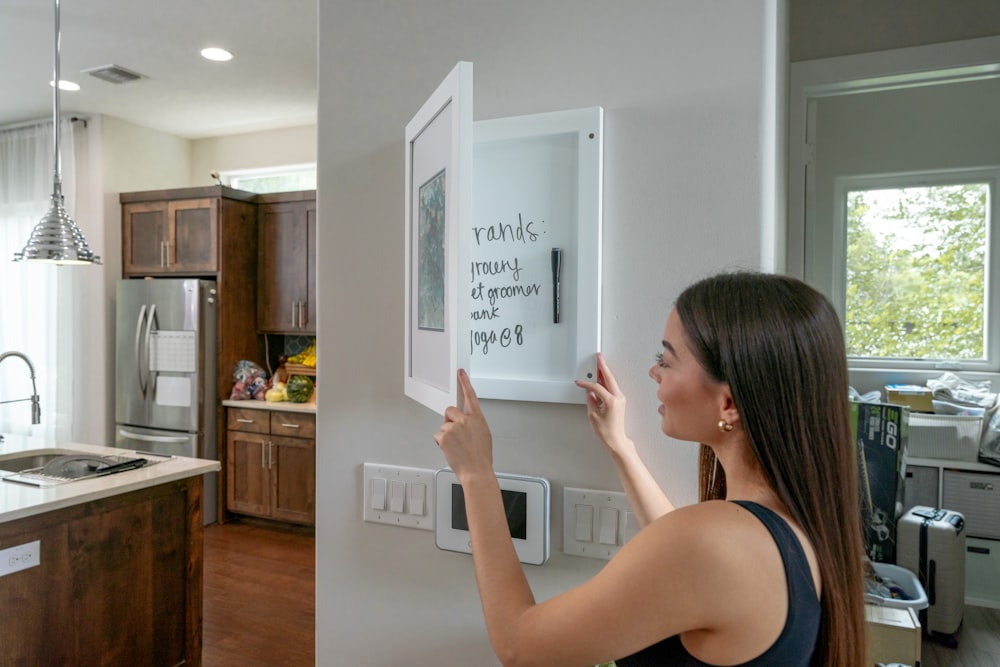 a woman is holding a magnet in a kitchen