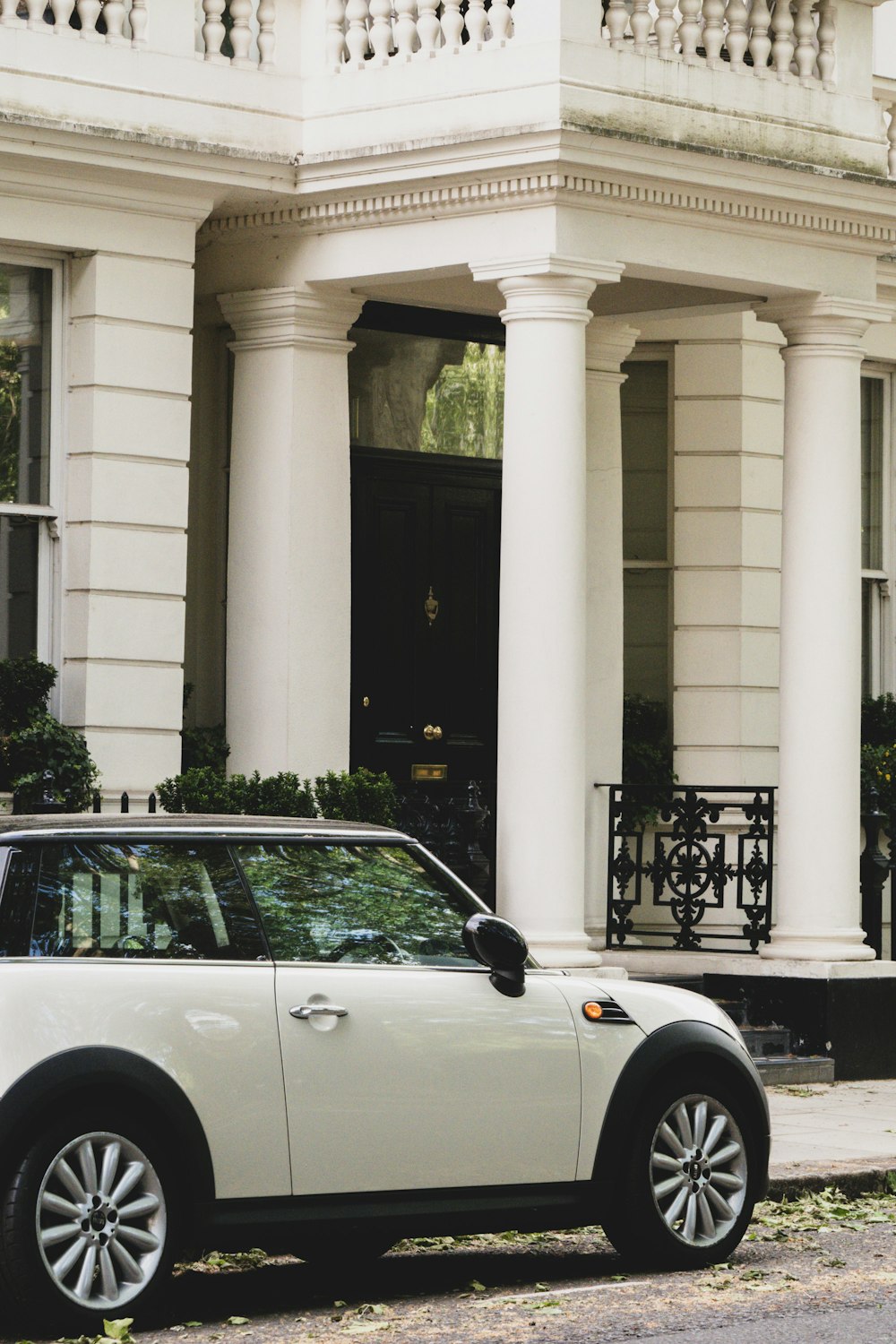 a white car parked in front of a white building