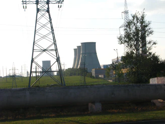 Technician inspecting a 50 MW gas generator in an outdoor power plant setting.