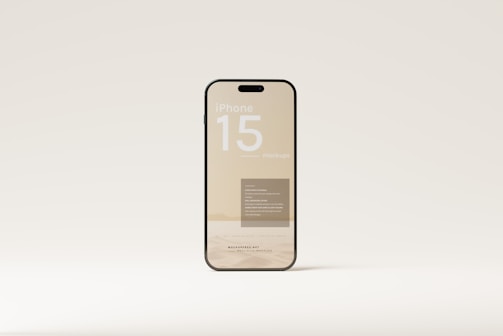 A smartphone with a clear, minimalist design appears to be the focus. The screen displays text, including 'iPhone 15 mockups,' and other smaller print. It is set against a neutral background, highlighting the device's sleek and modern aesthetics.