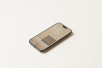 Close-up of a sleek iPhone 15 Pro Max displaying vibrant screen colors on a wooden table.