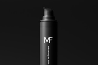 a bottle of mf hair products on a black background