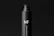 A sleek, black bottle with a pump dispenser top. The bottle has a matte finish and features the text 'MF' in large white letters, with 'pump bottle mockups' written vertically beneath it. The background is also black, creating a minimalist and modern aesthetic.
