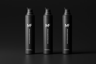 Three sleek black pump bottles with the logo 'MF' and the text 'slim & tall pump bottle mockups' are organized in a row against a dark background. The bottles have a minimalist and modern design.