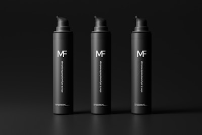 Three sleek black pump bottles with the logo 'MF' and the text 'slim & tall pump bottle mockups' are organized in a row against a dark background. The bottles have a minimalist and modern design.