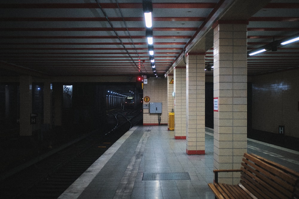 a train station with a bench and a train on the tracks