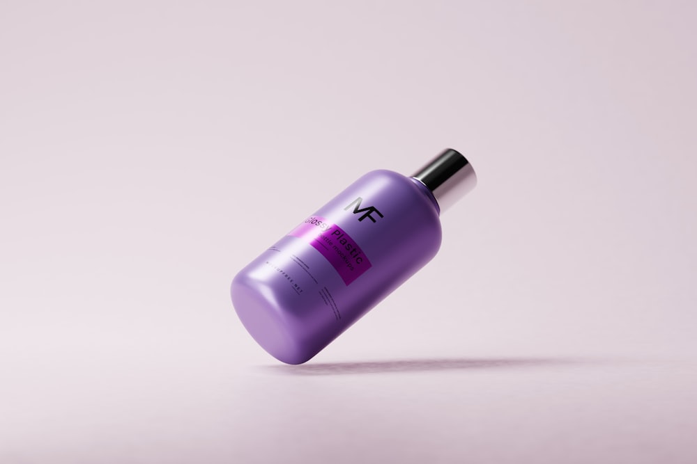 a purple bottle with a black top on a white surface