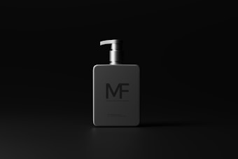A modern, minimalistic bottle with a dispenser pump is centered on a dark background. The bottle is sleek and square, featuring the letters 'MF' prominently on the front. The design is clean and understated, emphasizing sophistication.