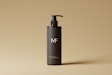 a bottle of mf shampoo on a tan background