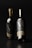 Two elegant wine bottles with a sleek design featuring gold caps. The labels prominently display large initials 'MF' in an understated yet sophisticated style, accompanied by smaller text below. The bottles are set against a dark background, emphasizing their dark, glossy appearance.