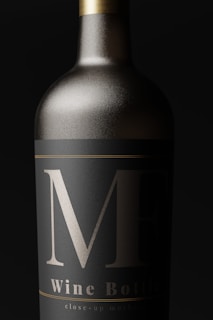A close-up view of an elegantly designed wine bottle with a matte black label and bold silver markings. The bottle appears metallic, with a sleek, sophisticated look.