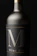 Elegant wine bottle with a dark matte label and gold accents on a black background.