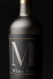 A close-up view of an elegantly designed wine bottle with a matte black label and bold silver markings. The bottle appears metallic, with a sleek, sophisticated look.
