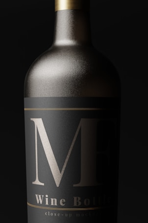 A close-up view of an elegantly designed wine bottle with a matte black label and bold silver markings. The bottle appears metallic, with a sleek, sophisticated look.