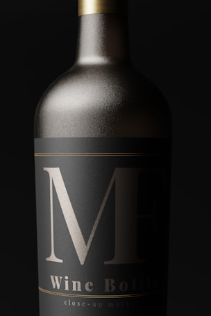 A close-up view of an elegantly designed wine bottle with a matte black label and bold silver markings. The bottle appears metallic, with a sleek, sophisticated look.