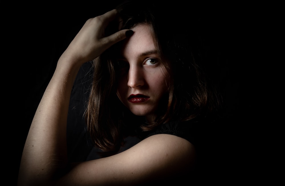 a woman is posing for a picture in the dark