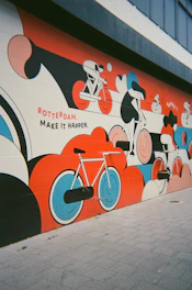 A vibrant artist painting a colorful mural on a Rotterdam wall.
