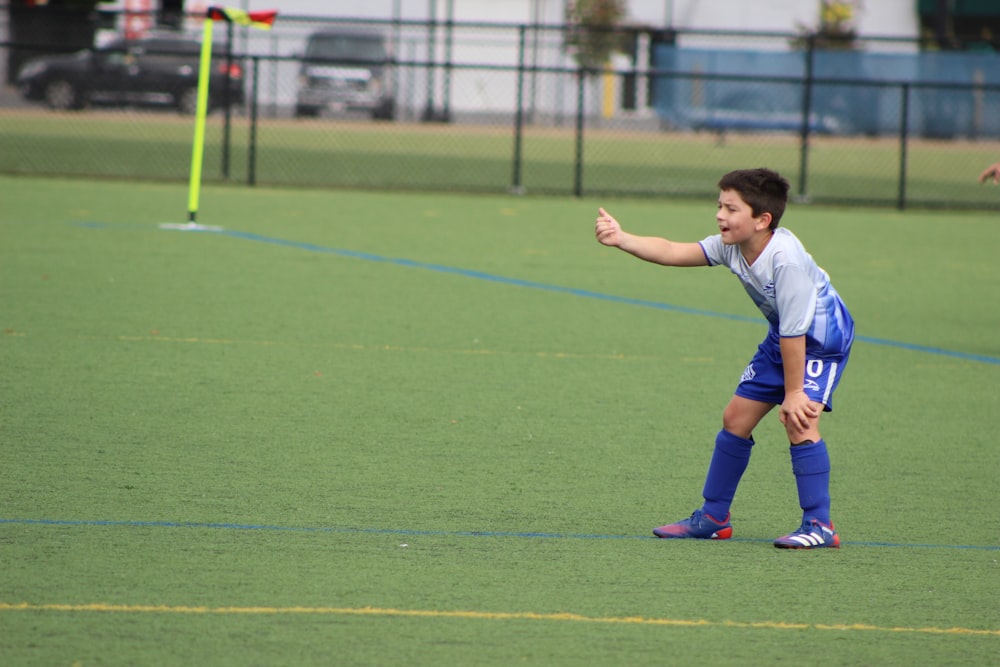 a young man standing on top of a soccer field