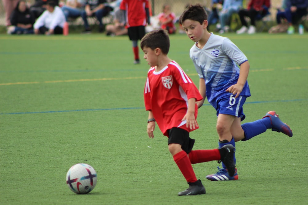 a couple of kids are playing soccer on a field