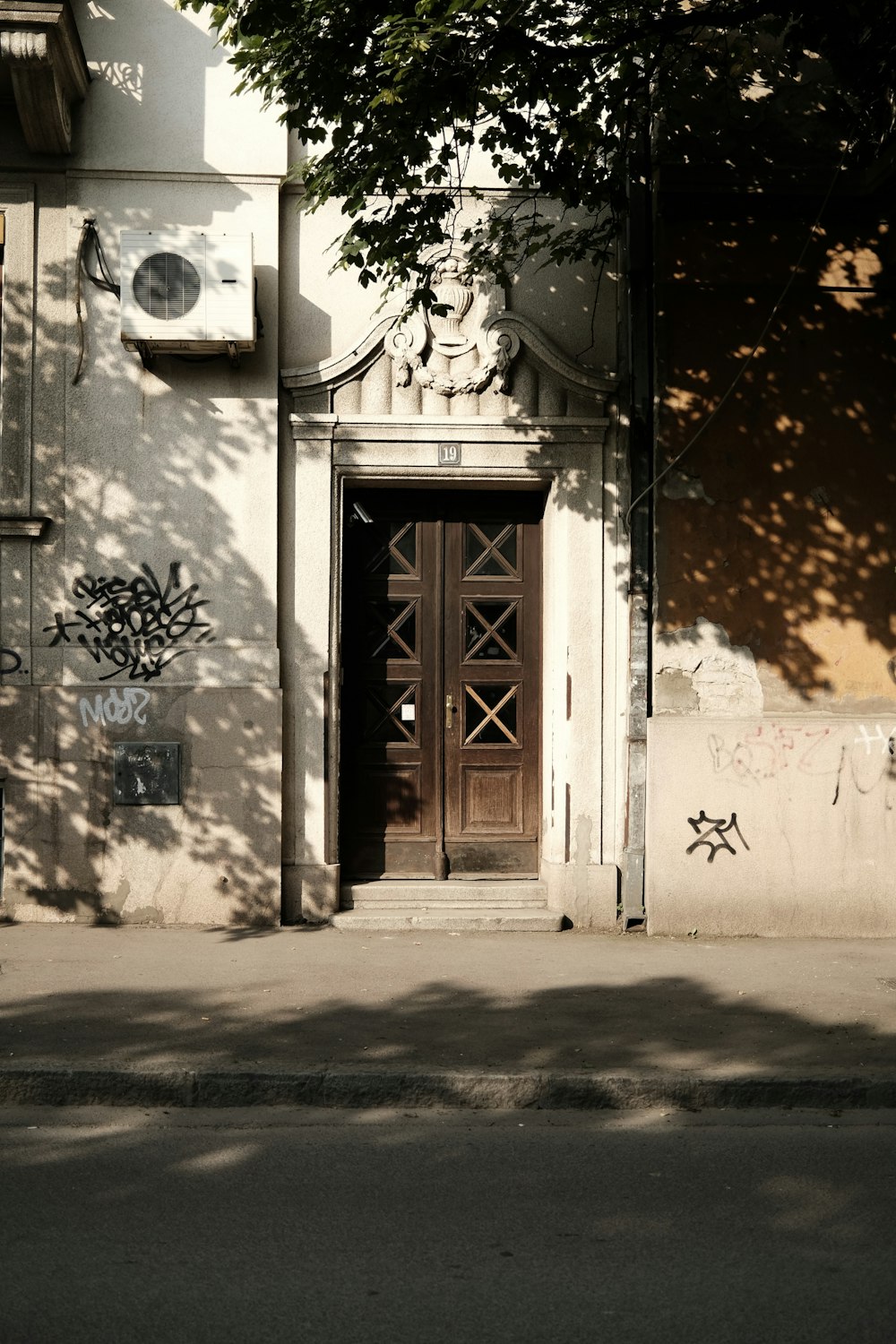 a building with a door and a tree in front of it