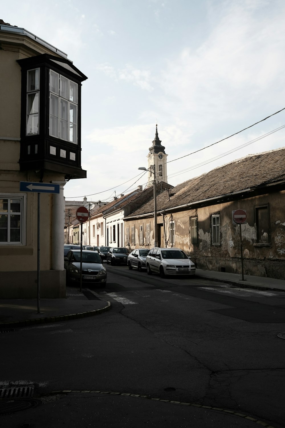 uma rua da cidade com uma torre do relógio ao fundo