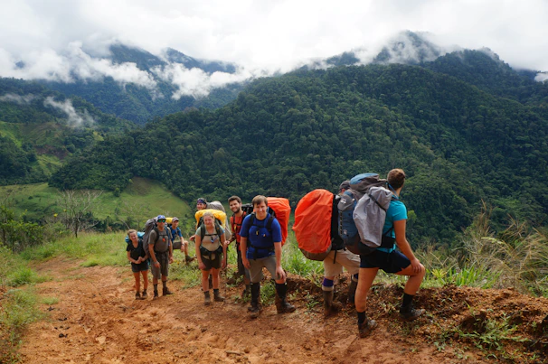 A small group of hikers pausing at a scenic viewpoint overlooking the lush green valley below.