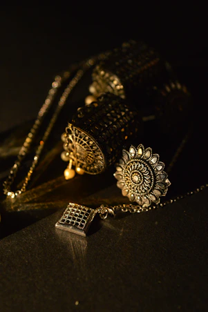 a black table with a gold necklace and a cell phone on it