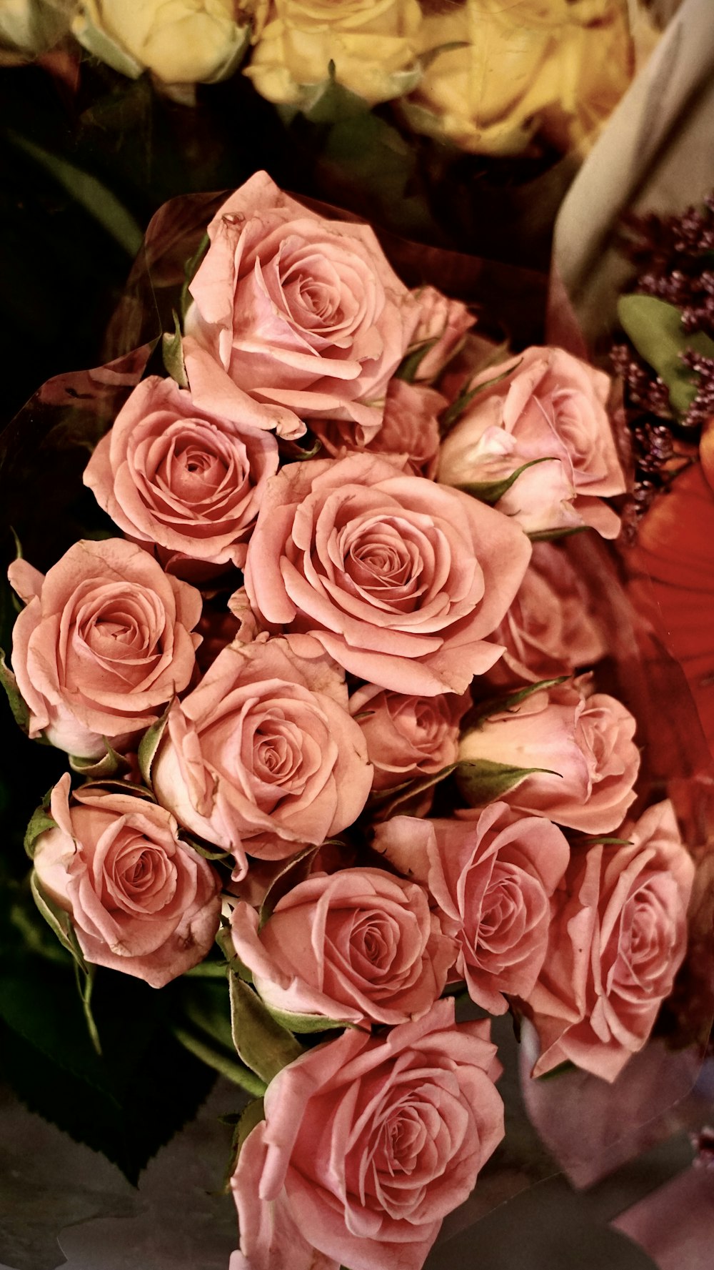 a bouquet of pink roses sitting on top of a table