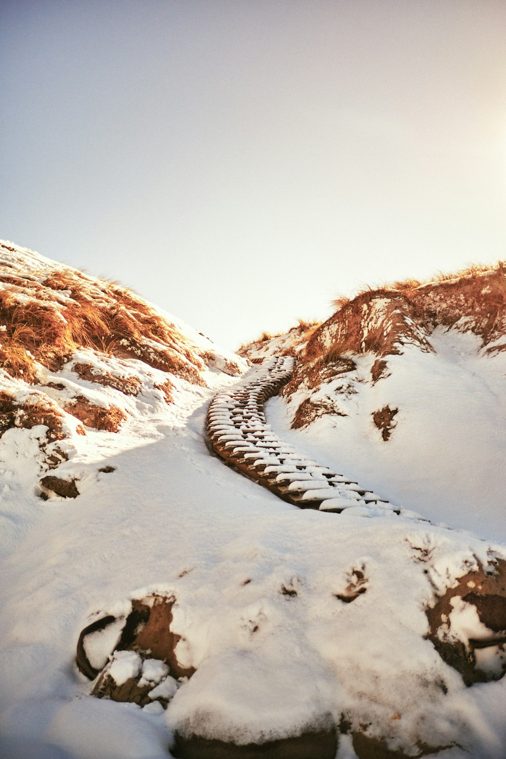 a snow covered mountain side with a train track