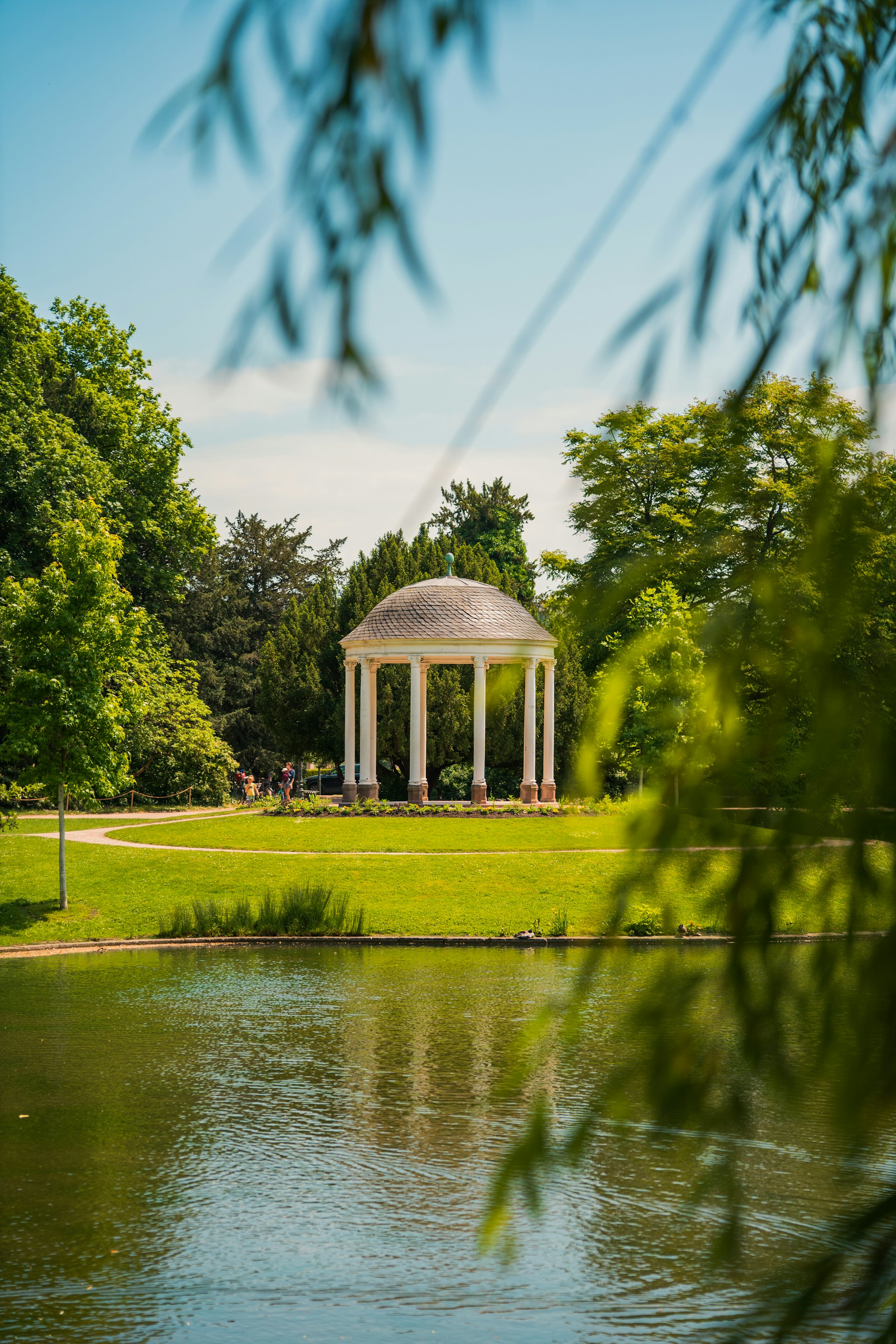 a gazebo in a park next to a lake